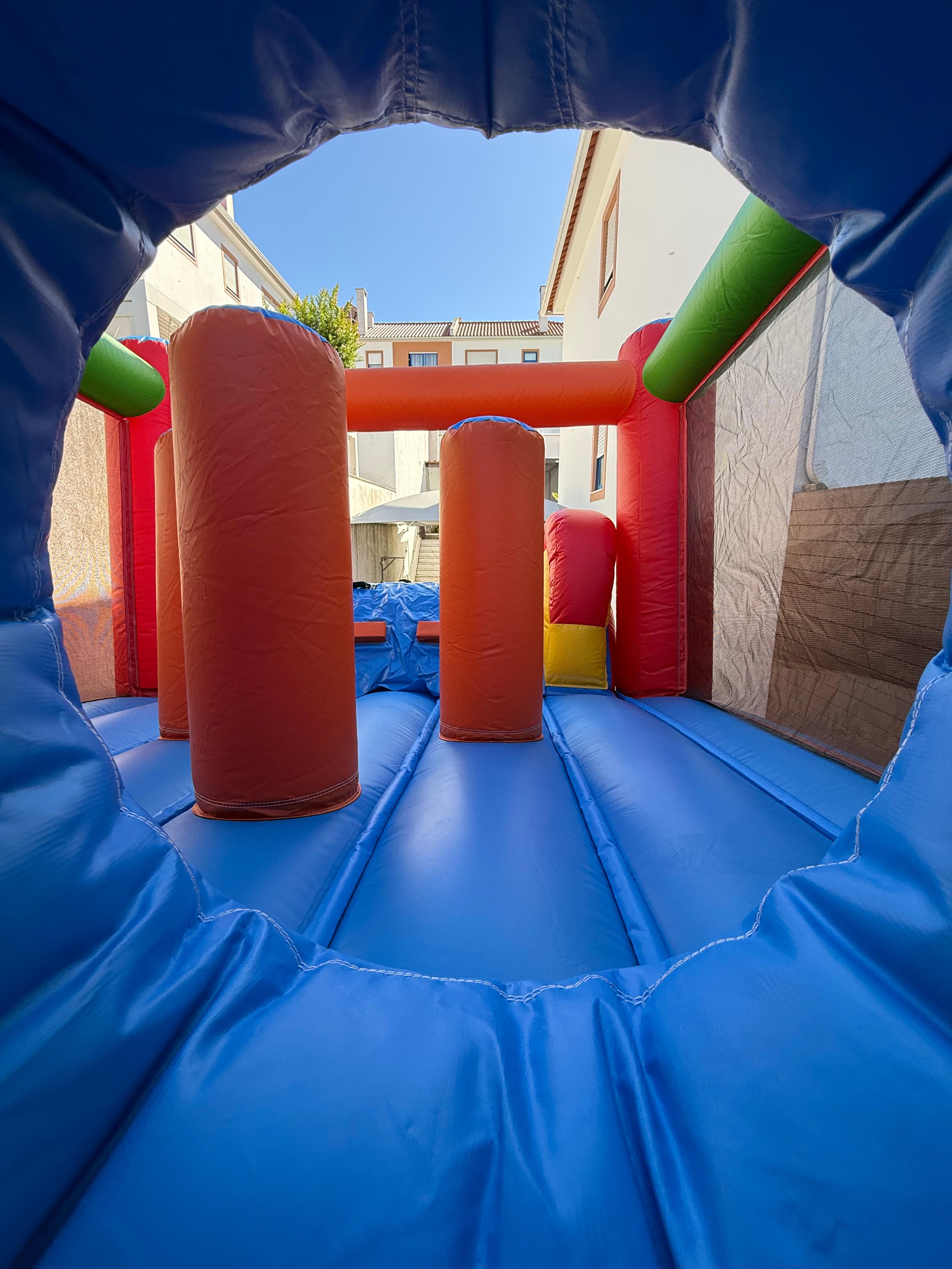 Interior de um insuflável com obstáculos numa festa infantil